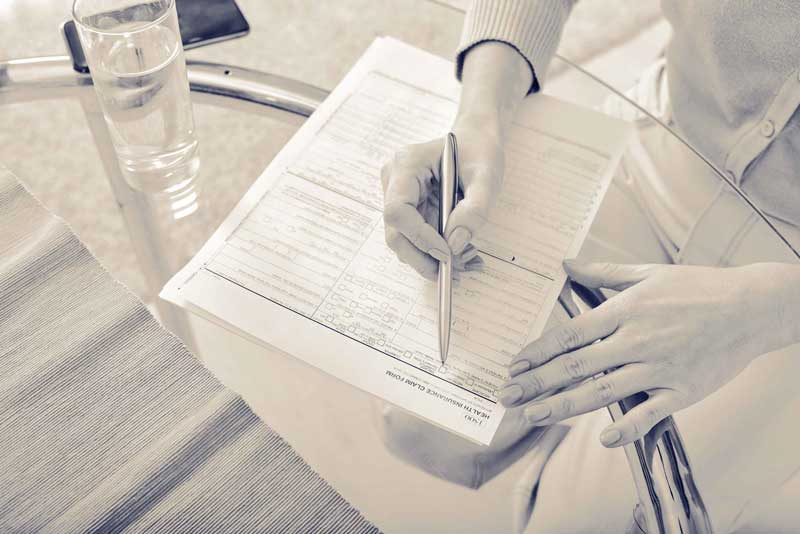 formular_duplex zwei Hände studieren ein umfangreiches Formular. Kugelschreiber in einer Hand